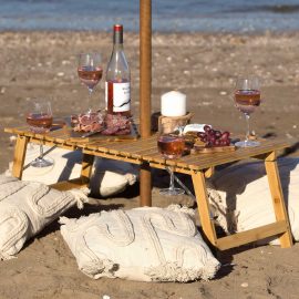 The Catalogue Ombrello Tavolo Table is an alfresco, foldable bamboo table with wine glass holders. Pack away into the included carry bag.