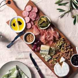 The Catalogue Serving Board is an acacia hardwood board with a bevelled handle. Leather loop for hanging. Each board is unique.